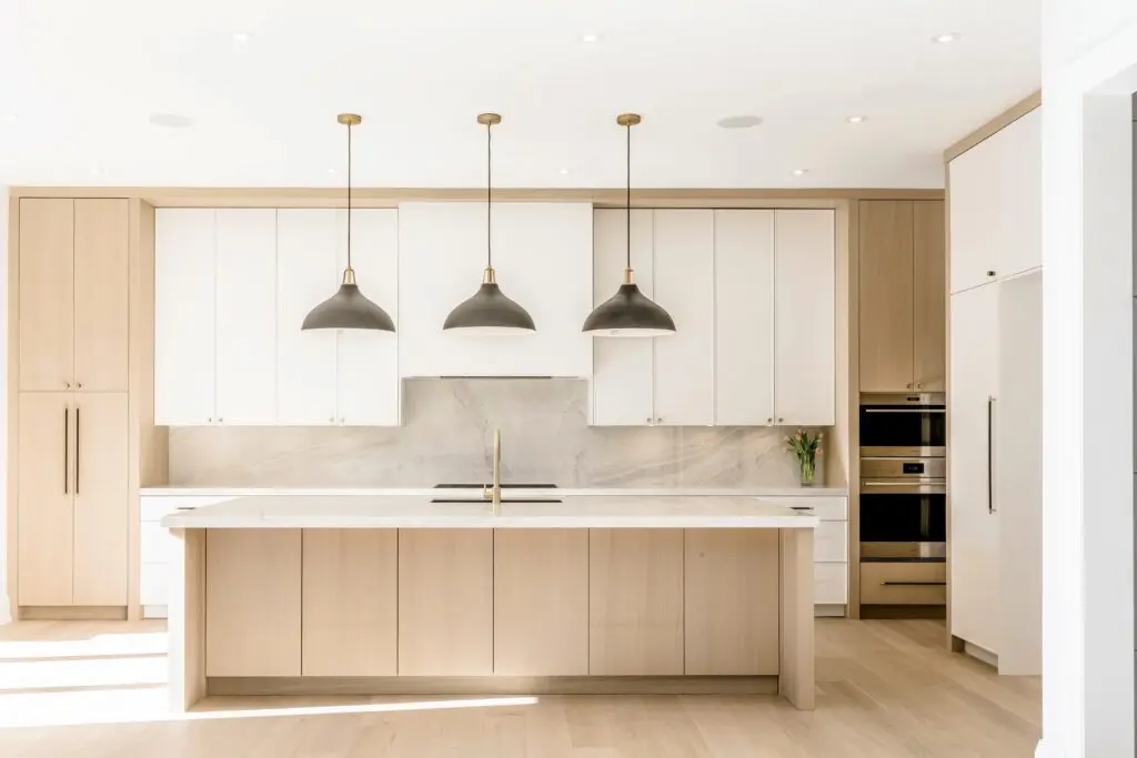 A kitchen with three lights hanging above the island.