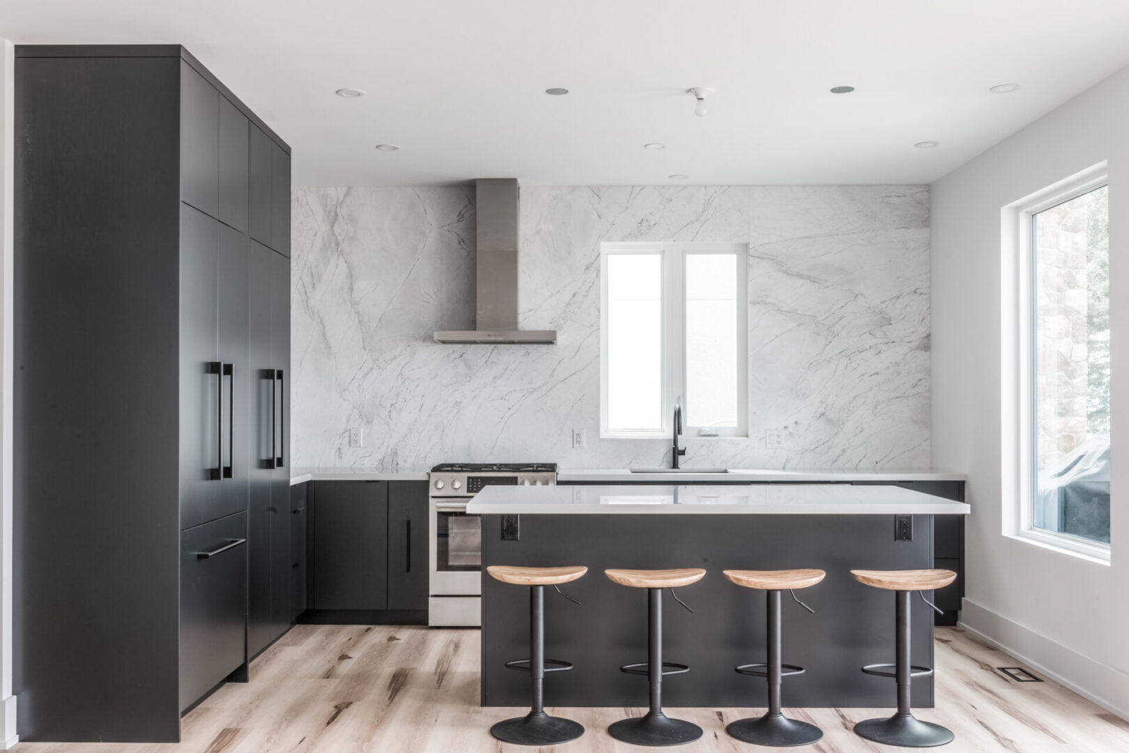 A kitchen with black cabinets and white walls.